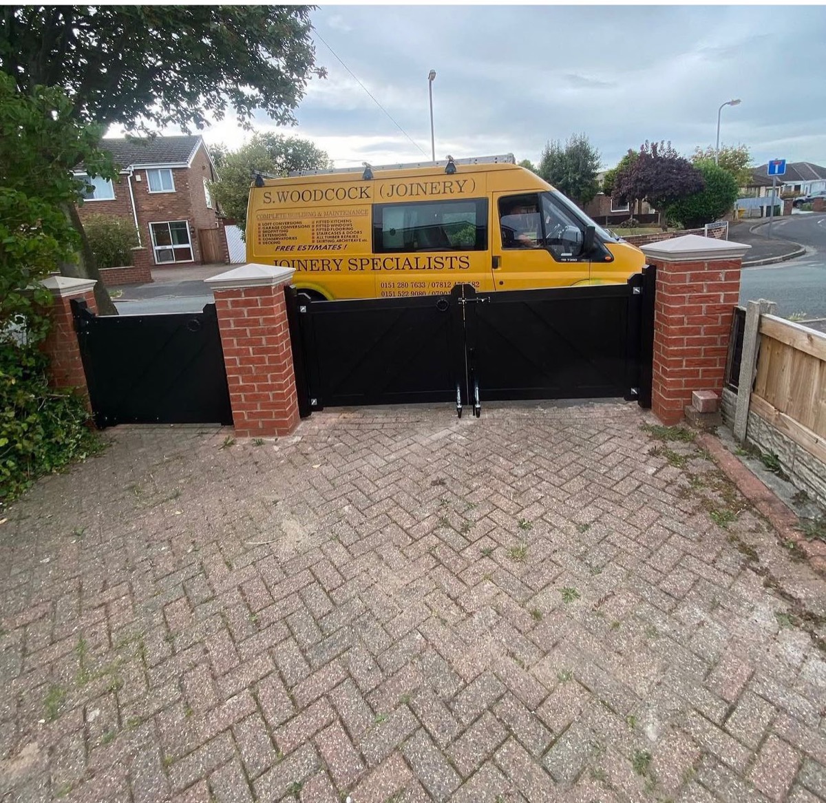 Black painted timber driveway gates with branded joinery van, Liverpool