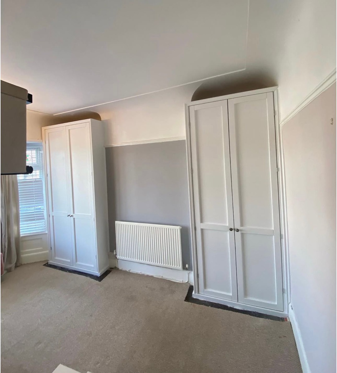 Twin white fitted alcove wardrobes either side of radiator, Liverpool