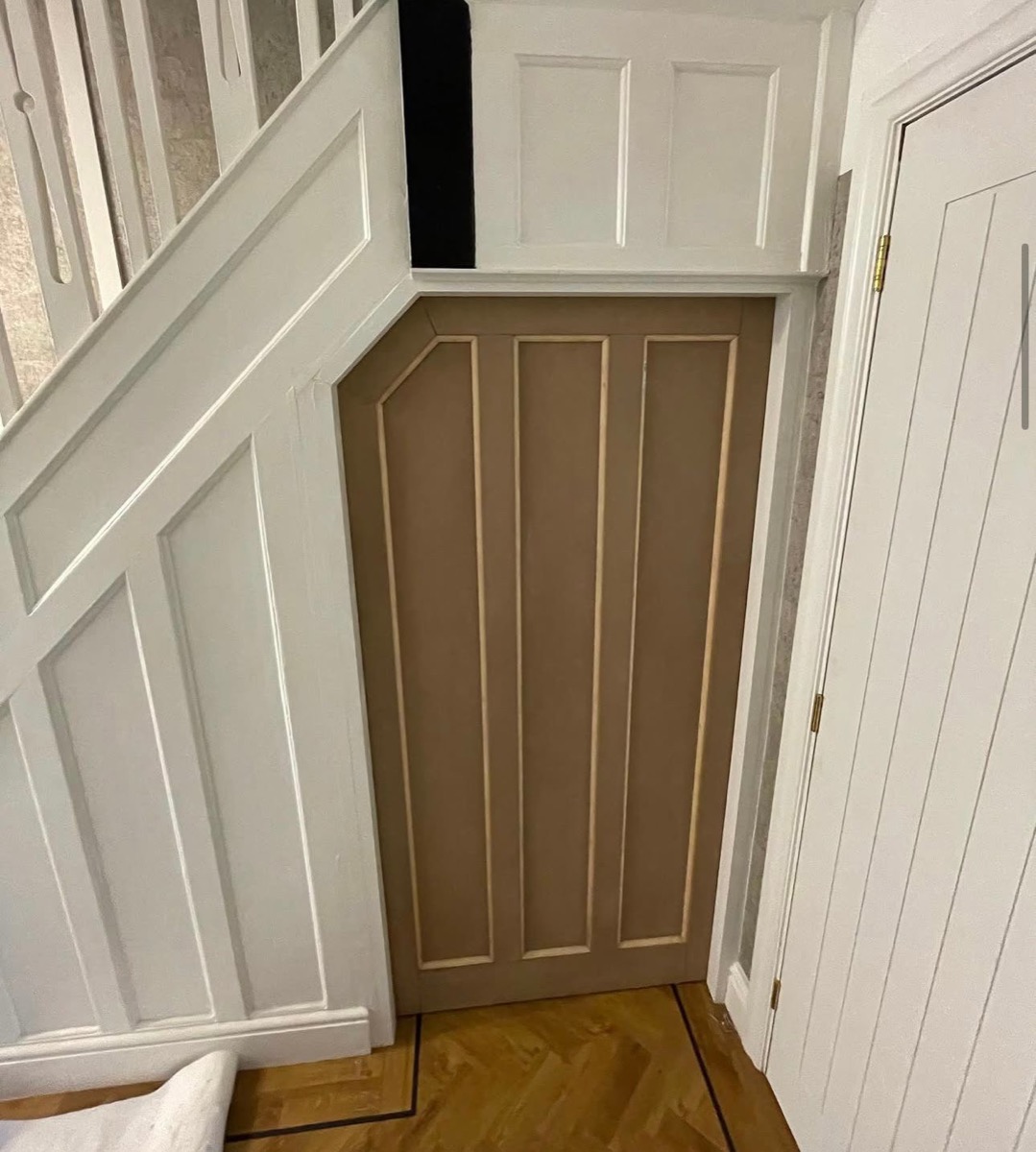 Bespoke panelled storage cupboard doors fitted under staircase