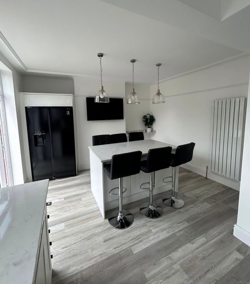 White shaker kitchen island with bar stools and marble worktop